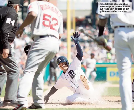  ??  ?? Jose Iglesias glisse sauf au marbre après que Ian Kinsler eut frappé un double en cinquième manche.