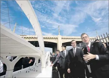  ?? Irfan Khan
Los Angeles Times ?? LOS ANGELES City Engineer Gary Moore, right, explains features of the new 6th Street Viaduct to Mayor Eric Garcetti and other city officials at an unveiling ceremony near the existing bridge, at rear.