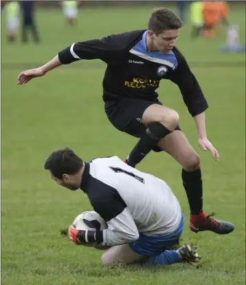  ??  ?? Conary United goalkeeper Andy Kennedy gathers the ball at the feet of Des Kelly of Ballywaltr­im.