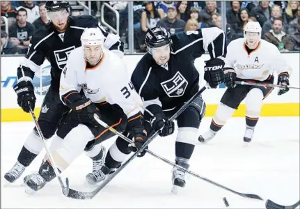  ??  ?? Daniel Winnik #34 of the Anaheim Ducks goes after the puck with Drew Doughty #8 and Jake Muzzin #6 of the Los Angeles Kings during the first period at Staples Center on Feb 25, in Los Angeles, California. (AFP)