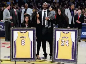  ?? CHRIS CARLSON — THE ASSOCIATED PRESS ?? Former Los Angeles Laker Kobe Bryant poses with his family during an NBA basketball game between the Los Angeles Lakers and the Golden State Warriors in Los Angeles, Monday. The Lakers retired Bryant’s No. 8 and No. 24 jersey during a halftime ceremony.