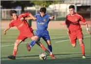  ??  ?? Above top: The East's Damian Rodriguez reacts to a shot Saturday. Above below: The East's Osvaldo Ibarra, center, battles for a ball Saturday