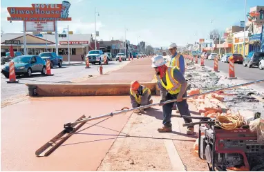  ?? MARLA BROSE/JOURNAL ?? Workers smooth concrete on the Central Avenue median in Nob Hill during ART constructi­on Thursday.