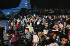  ?? Khalil Mazraawi//Tribune News Service ?? Evacuees from Sudan arrive at a military airport in Amman, Jordan, on Monday. A stream of military aircraft flew into Sudan all day Sunday and Monday to take foreigners out.