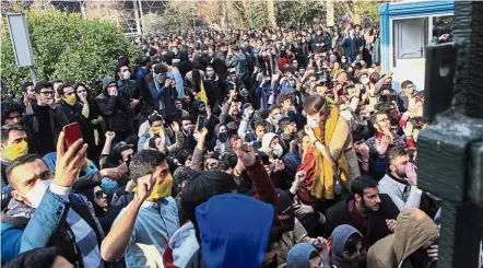  ?? — AP ?? Voice of the youth: University students attending a protest inside Tehran University while anti-riot Iranian police prevent them to join other protestors, in Teheran.