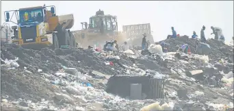  ??  ?? MESSY JOB: Waste collectors dig through rubbish on the Berlin dumpsite to find any item of food or value