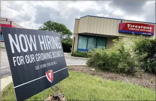  ?? THE ASSOCIATED PRESS ?? A hiring sign at Firestone Complete Auto Care store in Arlington Heights, Ill. Illinois Governor J.B. Pritzker said that the state may join the list of others in offering incentives for people to return to work.