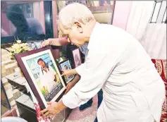  ??  ?? This photo file shows Gopal with a picture of his son at his residence in Guwahati. — AFP photos