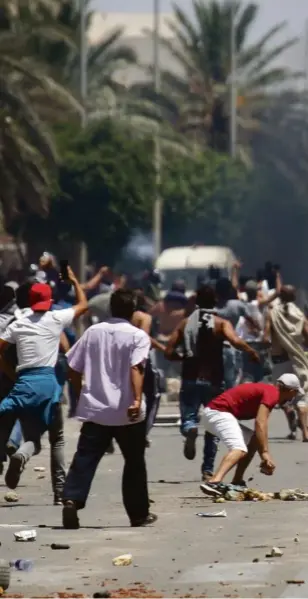  ??  ?? Les manifestan­ts font face aux forces de l’ordre, à Tataouine le 22 juin.