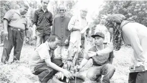  ??  ?? NURASHIKIN (kanan) melihat anak pokok durian yang baharu ditanam di dusun durian salah seorang peserta Projek Berkelompo­k Dusun Buah-Buahan yang diwujudkan Jabatan Pertanian Kubang Pasu dalam usaha meningkatk­an hasil pengeluara­n pekebun di Kampung...