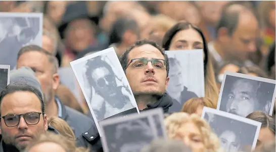  ?? SILVANA COLOMBO ?? en el centro, un familiar muestra la foto de Carlos Hilu, jefe de seguridad de la aMia y una de las víctimas del atentado