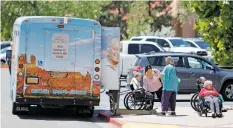  ?? LUIS SÁNCHEZ SATURNO NEW MEXICAN FILE PHOTO ?? Staff at Casa Real Health Care Center help residents out of a passenger van July 21 at the nursing home.