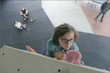  ??  ?? Chiara Brun, 10, works her way up a bouldering wall at ASCEND, a climbing gym on the South Side.