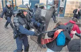  ?? LOIC VENANCE/GETTY-AFP ?? An anti-riot police officer fends off protesters during a demonstrat­ion against pension reform Saturday in Nantes, western France. The nationwide protests began Thursday.