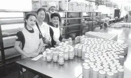  ??  ?? PACKAGED WHITE UBE - Sr. Guadalupe Bautista, RGS (2nd from left), and the female student workers of MMTC posing with packaged white ube jam.