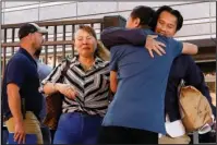  ?? The Associated Press ?? RELEASED: Ammala Mingsouan embraces family outside the building that houses Immigratio­n and Customs Enforcemen­t and the Atlanta Immigratio­n Court after being released from ICE custody on June 12 in Atlanta. Mingsouan’s mother Littun Saenboutta­iath, right, said she had not seen him for 24 years.