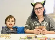  ??  ?? Asher Chavez, 7, and Shawna Coydell of Boyertown play the Munchkin card game at the Deal Me In Games’ Library Comic Con table.