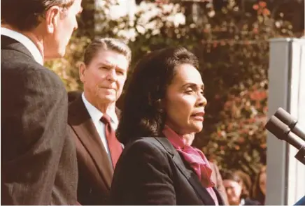  ?? PETE SOUZA/WHITE HOUSE ?? Civil rights activist Coretta Scott King speaks at the White House bill signing ceremony to establish a federal holiday to honor her late husband, the Rev. Martin Luther King Jr., in Washington on Nov 2, 1983. Behind her is President Ronald Reagan.