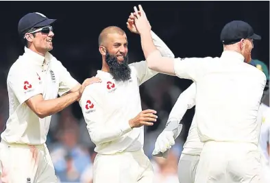  ?? Picture: Getty Images. ?? Moeen Ali is congratula­ted after claiming the wicket of Dean Elgar.
