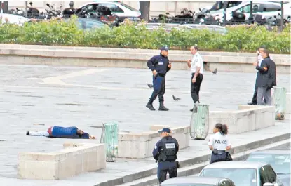  ?? REUTERS ?? Varios policías franceses permanecen junto al atacante herido, en el suelo, cerca del templo de Notre Dame.