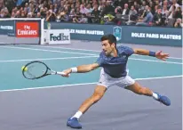  ?? THIBAULT CAMUS/ASSOCIATED PRESS ?? Novak Djokovic stretches for the ball to return it to Karen Khachanov during their final match of the Paris Masters on Sunday at the Bercy Arena in Paris. Djokovic returned to No. 1 on Monday after a two-year absence, replacing Rafael Nadal.