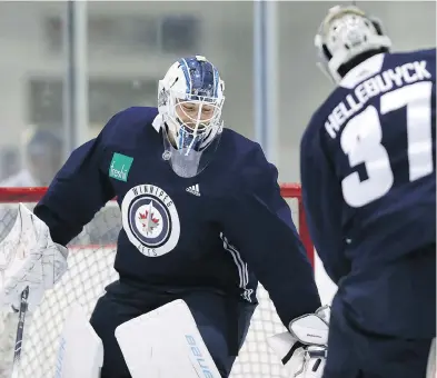  ?? KEVIN KING / POSTMEDIA NETWORK ?? Winnipeg goaltender­s Laurent Brossoit and Connor Hellebuyck horse around during an informal workout. The pressure is again on the 25-year-old Hellebuyck to lead the Jets.