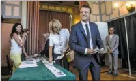  ?? The Associated Press ?? FRANCE: French President Emmanuel Macron and his wife Brigitte Macron pick up ballots before voting in the first round of the two-stage legislativ­e elections Sunday in Le Touquet, northern France. French voters are choosing legislator­s in the first...