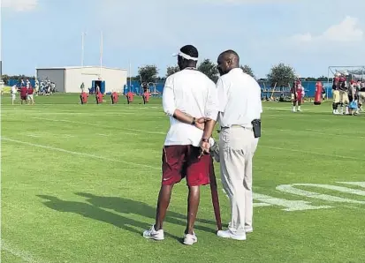 ?? SAFID DEEN/STAFF ?? FSU coach Willie Taggart, left, talks with former Seminoles star Derrick Brooks during the team’s first workout Monday at IMG Academy.