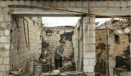  ?? NICOLE TUNG/THE NEW YORK TIMES ?? Tetiana Bykova stands in what was the kitchen of a destroyed home in her family’s complex on Friday in Irpin, Ukraine. Four houses belonging to an extended family were destroyed by Russian strikes in March.