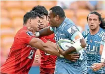  ?? GETTY IMAGES ?? Manasa Mataele tries to fend off a Sunwolves tackler during Saturday’s match in Brisbane.