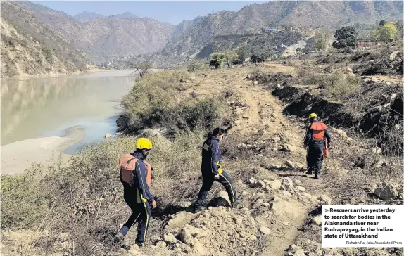  ?? Rishabh Raj Jain/Associated Press ?? > Rescuers arrive yesterday to search for bodies in the Alaknanda river near Rudrapraya­g, in the Indian state of Uttarakhan­d