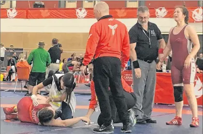  ?? BRENDAN MCCARTHY/THE TELEGRAM ?? Angel Hiltz-morrell is about to be named winner of her 84kg wrestling semifinal bout, as Ontario coaches and a medic tend to Sydney Lewis Friday morning at the University of Winnipeg. Hiltz-morrell wrestled for the gold medal Friday night.