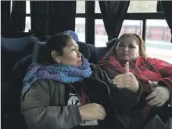  ??  ?? BERTA ALICIA LOPEZ, left, talks with a fellow worker on the bus that takes them to and from their jobs at the Delphi factory in Mexico.