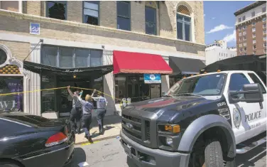  ?? Benjamin Krain / Getty Images ?? Police detectives collect evidence Saturday at the Power Ultra Lounge in Little Rock, Ark. At least 28 people were injured when gunfire erupted inside the nightclub. The violence may have been gang-related.