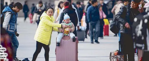  ?? AFP ?? Passengers arrive at a train station in the city of Wuhan in Hubei province yesterday.