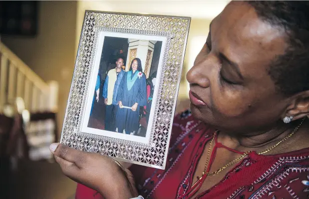  ?? —JASONPAYNE ?? Veronica Harrison-Dawkins holds a graduation photo of herself and her older brother, Claude Allen, who died in a still-unsolved Kingsway dance hall shooting in 2000. The family still hopes to see someone held responsibl­e for the killing and police are still working on the case.