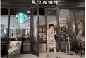  ?? — AFP ?? A customer walks out of a Starbucks coffee shop in Beijing.