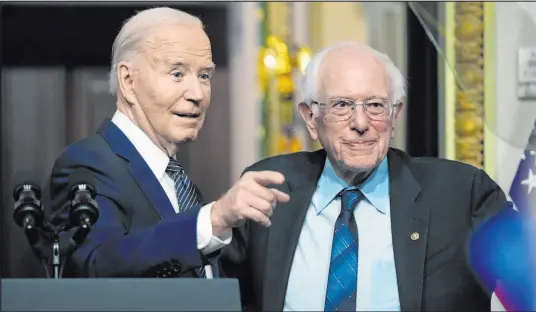  ?? Mark Schiefelbe­in The Associated Press ?? President Joe Biden stands with Sen. Bernie Sanders, I-VT., after speaking Wednesday about lowering health care costs in the Indian Treaty Room at the Eisenhower Executive Office Building on the White House complex.