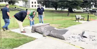  ??  ?? Personnel from the Secretary of State’s Office inspect the damage to the new Ten Commandmen­ts monument outside the state Capitol in Little Rock, Arkansas, yesterday, after someone crashed into it with a vehicle, less than 24 hours after the privately...