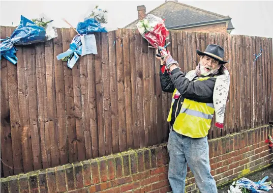  ??  ?? In Hither Green, resident Iain Gordon takes down flowers laid in memory of Henry Vincent, the burglar who was stabbed to death, while, below, a police officer patrols the scene