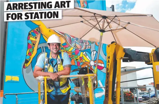  ?? Picture: SHAE BEPLATE ?? CONNECTION­S: Darwin artist Hafleg puts the finishing touches to his street art mural.