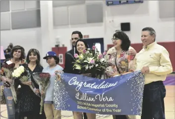  ?? CORPUS PHOTO ELIZABETH MAYORAL ?? Lillian Vera (center, holding flowers) receives a recognitio­n as 2023 ASCA Imperial County School Counselor of the Year alongside her family, on Friday, March 10, the Wilson Junior High School Gymnasium in El Centro.