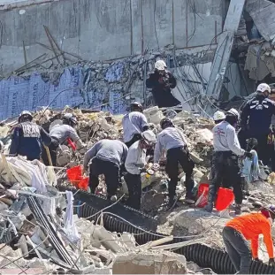  ?? (Reuters) ?? RESCUE PERSONNEL work at the scene of the partially collapsed Champlain South Towers condominiu­m in Surfside, Florida.