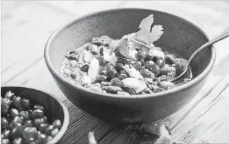  ?? ANDREW SCRIVANI NYT ?? A bowl of red bean stew with fried onions and cilantro, garnished with pomegranat­e seeds, raw onion and feta.