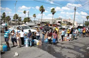  ?? Associated Press ?? ■ Neighbors wait in line to collect water in plastic containers Monday in Monterrey.