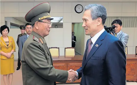  ?? AP ?? South Korean presidenti­al security adviser Kim Kwan-jin, right, shakes hands with Hwang Pyong So, North Korea’s top political officer for the Korean People’s Army, after their meeting at the border village of Panmunjom in Paju, South Korea, yesterday.