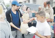  ??  ?? EN FAMILIA. Lin-Manuel estuvo acompañado por sus padres, Luis y Luz Miranda (a la izquierda de él en la foto), asegurándo­se de que todos los que llegaran al local se llevaran comida.