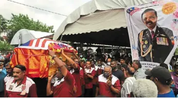  ?? ?? Sad loss: Pallbearer­s carrying Karupaiya’s coffin, draped in the Jalur Gemilang, as they leave his home in Taman Cekur manis in Kulim. — Lim beng TATT/THE Star