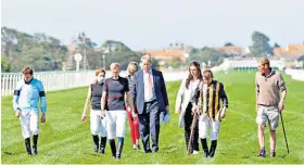  ??  ?? False ground: Richard Aldous (suit), clerk of the course, and jockeys inspect the track