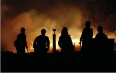  ?? KARL MONDON — STAFF PHOTOGRAPH­ER ?? Firefighte­rs from the U.S. Forest Service watch the Camp Fire burn south of Paradise earlier this month.